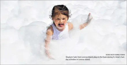 ?? DESIREE ANSTEY/JOURNAL PIONEER ?? Shaylynn Sark, from Lennox Island, plays in the foam during St. Anne’s Sunday activities in Lennox Island.