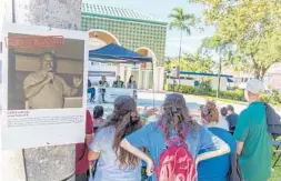  ?? JENNIFER LETT/STAFF PHOTOGRAPH­ER ?? Over a dozen posters with photos of people who sacrificed their freedom and lives were placed on the trees in Sanborn Square Park in Boca Raton on Sunday.