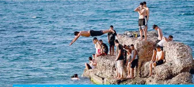  ?? —AFP ?? TRIPOLI: Libyans swim off the coasts of the capital Tripoli.