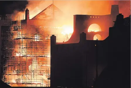  ?? JEFF J MITCHELL GETTY IMAGES ?? Firefighte­rs battle a blaze in the Mackintosh Building at the Glasgow School of Art for the second time in four years early Saturday. It was designed in the late 1890s by architect Charles Rennie Mackintosh and completed in 1909. It is widely...