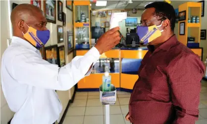  ?? Photograph:Aaron Ufumeli/EPA ?? ‘Many African countries, scarred by previous pandemics, realised quickly that there was very little room for error, and did what they needed to do.’ A man has his temperatur­e checked in a shop Harare, Zimbabwe, in October.