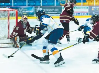  ??  ?? Marie-Pier Corriveau, des Aigles Bleues de l’U de M, tente de prendre de vitesse la gardienne Keri Martin, des Mounties de l’Université Mount Allison. Collaborat­ion spéciale: Marc Grandmaiso­n