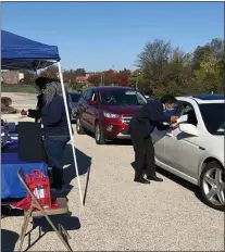  ?? ASSOCIATED PRESS ?? In this Oct. 31, 2020photo provided by Dr. Carmen Guerra of the University of Pennsylvan­ia, volunteers work at a drive-thru flu shot event in Stenton, Pa., where they also distribute­d home test kits to detect possible signs of colon cancer. Guerra had a federal grant to increase cancer screening in racially diverse communitie­s and realized that home tests could help fill a gap.