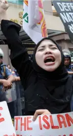  ?? (AGENCE FRANCE PRESSE) ?? A protester shouts slogans as she attends a rally against the Malaysian government in front of the Malaysian embassy in Manila.