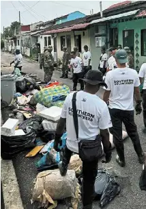  ?? ?? In the aftermath: southern Volunteers members and army personnel cleaning up discarded waste in Kampung Tembioh, Kota Tinggi.