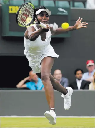  ?? Tim Ireland ?? The Associated Press Tenth-seeded Venus Williams returns a shot to Belgium’s Elise Mertens during their first-round singles match Monday at Wimbledon. Williams, a five-time Wimbledon champion, won 7-6 (7), 6-4.
