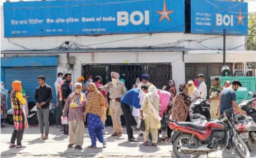  ?? File/agence France-presse ?? Customers stand outside a bank branch in Amritsar, India.