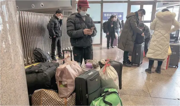  ?? Associated Press ?? ↑
Travellers wearing face masks arrive at the West Railway Station in Beijing on Friday.