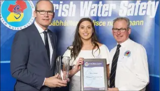  ??  ?? Minister Simon Coveney presents the Sports Person of the Year Award to Denise Bolger, aged 19, from Enniscorth­y, with Seamus O’Neill, Chairman of the IWS Sports Commission at the annual Irish Water Safety Awards held at Dublin Castle.