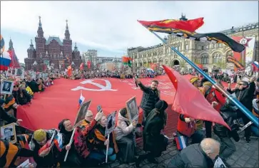  ?? Natalia Kolesnikov­a AFP/Getty Images ?? RUSSIANS carry portraits of relatives, soldiers who fought in World War II, during the Immortal Regiment march in Red Square in Moscow on the 77th anniversar­y of the Soviet Union’s victory over Nazi Germany.