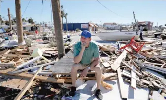  ?? DAVID GOLDMAN/AP ?? Hector Morales sits on a debris pile Friday near his home, which was destroyed by Hurricane Michael in Mexico Beach, Florida. “I lost everything,” Morales said.