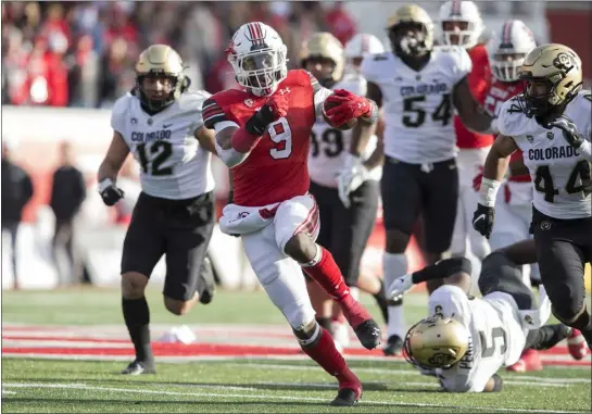  ?? PHOTOS BY CHRIS GARDNER — GETTY IMAGES ?? Tavion Thomas (9) of the Utah Utes rushes the ball against the Colorado Buffaloes during their game November 26, 2021at Rice-eccles Stadium in Salt Lake City, Utah.