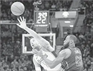  ?? Tony Dejak Associated Press ?? JOSH HART of the Lakers reaches for the ball while being guarded by LeBron James of the Cavaliers in the first half. Hart scored 11 points in a season-high 32 minutes.