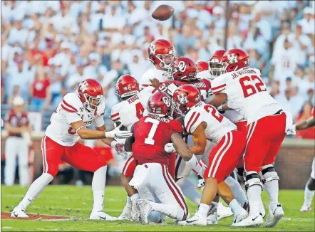  ?? [BRYAN TERRY/ THE OKLAHOMAN] ?? The Oklahoma defense swarms Houston quarterbac­k D'Eriq King (4) to force a fumble in the first half of the Sooners' win Sunday in Norman.