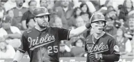  ?? MARK J. TERRILL/AP ?? The Orioles’ Anthony Santander, left, pats Ramon Urias on the head after they scored on a single by Robinson Chirinos in the second inning Friday night in Anaheim, California. Baltimore jumped out to a 5-0 lead and held on for a 5-3 victory.