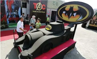  ?? GUSLAN GUMILANG/JAWA POS ?? ALA-ALA THEME PARK: Replika Batmobile di posko mudik Polres Gresik di Jalan Raya Duduksampe­yan.