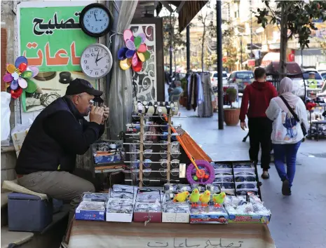  ?? AP ?? Lebanese street seller Salah Nasab sells clocks and watches displaying both times in the southern port city of Sidon