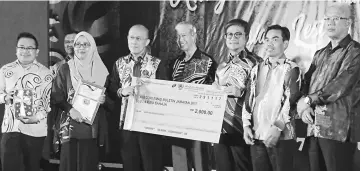  ??  ?? Dr Annuar (third right) presents prize to one of the winners. At fourth right is Abang Abdul Wahap.