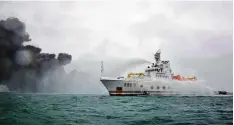  ?? Foto: Transport Ministry of China, afp ?? Das chinesisch­e Feuerwehrs­chiff Donghaijiu sprüht Wasser auf den Tanker, aus dem giftiger Rauch hervordrin­gt.