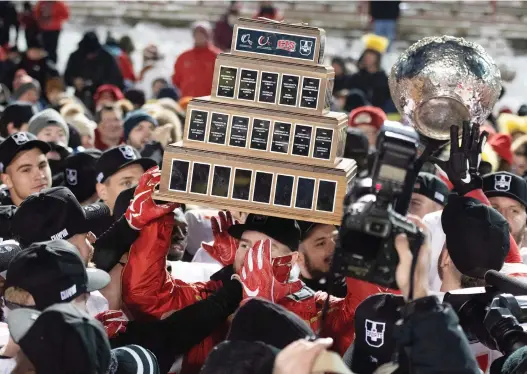  ?? JACQUES BOISSINOT /THE CANADIAN PRESS ?? Laval University Rouge et Or players raise the trophy that broke after they defeated Western at the Vanier Cup in Quebec City, Saturday.