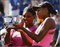  ?? Darron Cummings / Associated Press ?? Serena Williams, left, and her sister Venus examine the championsh­ip trophy after winning the doubles championsh­ip at the U.S. Open in 2009.
