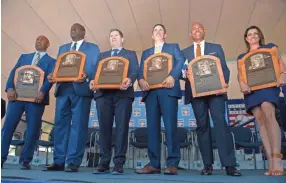  ??  ?? Hall of Fame inductees Harold Baines, from left, Lee Smith, Edgar Martinez, Mike Mussina, Mariano Rivera and Brandy Halladay – the widow of Roy Halladay – hold plaques Sunday in Cooperstow­n, N.Y. GREGORY FISHER/USA TODAY SPORTS