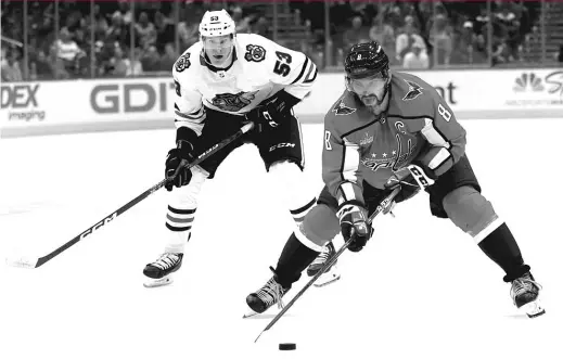  ?? PATRICK SMITH/GETTY IMAGES ?? Capitals superstar Alex Ovechkin skates past Hawks forward Buddy Robinson during the second period Thursday at Capital One Arena.