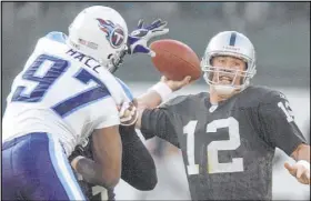  ?? Elaine Thompson The Associated Press ?? Raiders quarterbac­k Rich Gannon attempts to get off a pass against the pressure of Tennesse Titans DE Carlos Hall in 2003.