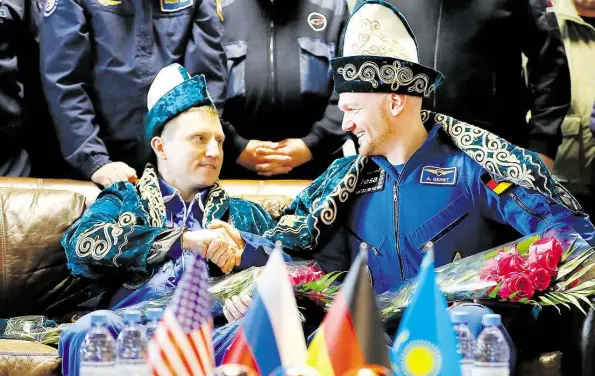  ?? DPA-BILD: ZHUMATOV ?? Gut gemacht, Partner! Kosmonaut Sergej Prokopjew (links) schüttelt Astronaut Alexander Gerst am Flughafen in Scheskasga­n die Hand.