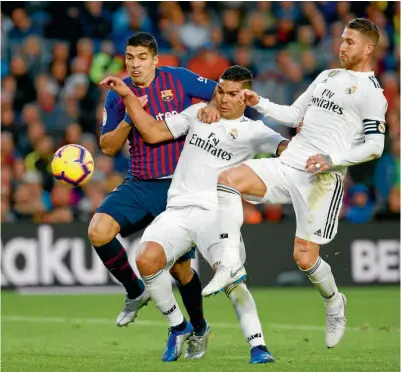  ??  ?? PERDIDOS. Casemiro y Ramos intentan detener a Luis Suárez, autor de tres goles, ayer en el Clásico.