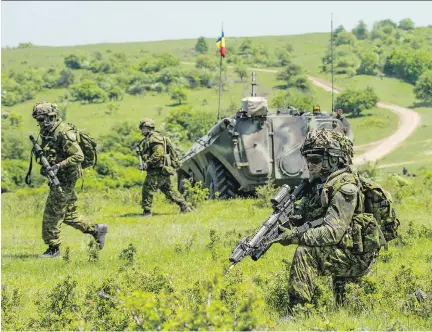  ?? DND ?? Members of 3rd Battalion, The Royal Canadian Regiment, react to an ambush during Exercise Sarmis in Cincu, Romania, on May 19. The exercise, aimed at deterring Russian aggression, has been big news in Romania and Russia, with Russian officials...