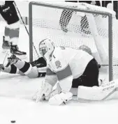  ?? KEITH SRAKOCIC/AP ?? The puck bounces out in front of Panthers goaltender Roberto Luongo as Penguins’ Bryan Rust slides into the goal after scoring during the first period Tuesday.