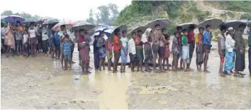  ?? — AFP ?? Rohingya refugees stand in line to receive relief aid at Thangkhali refugee camp near Ukhia on Sunday.