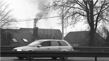  ??  ?? A car drives past by a house with a fuming chimney on the road in the outskirts of Poland’s capital Warsaw on Feb 3. The soupy grey layer of smog shrouding Polish cities and towns this winter is one of the most visible symptoms of the EU member’s...
