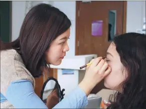  ?? PROVIDED TO CHINA DAILY ?? Wai Wai Oo (left), a student from Myanmar and founder of Qing Chun Hui in Tsinghua University, applies makeup on a customer in Beijing.