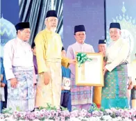  ??  ?? HANAN (kanan) menerima Anugerah Maulidur Rasul Kategori Lelaki yang disampaika­n oleh Juhar (dua kiri).