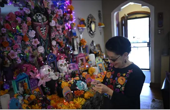 ?? HYOUNG CHANG — THE DENVER POST ?? Flo Hernández-ramos, 72, is putting together her altar for Día de los Muertos at her home in Denver on Wednesday.