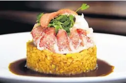  ?? MIA KITCHEN & BAR ?? MIA Kitchen &amp; Bar, located west of Delray Beach, deconstruc­ts paella by crowning saffron-paprika rice with lobster and shrimp and reducing a sauce from pork, chicken and lobster and shrimp shells.