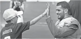  ??  ?? Titans fan Rowan Marko, 7, high-fives quarterbac­k Marcus Mariota after a joint practice Wednesday with the Bucs. Tennessee will host Tampa Bay on Saturday in a preseason game at Nissan Stadium. GEORGE WALKER IV / THE TENNESSEAN