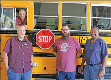  ?? ELISHA MORRISON/THE Saline Courier ?? Benton Transporta­tion staff, including Transporta­tion Director Danny Revis, left, mechanics Robin Creel and Josh Rodgers, and driver Karl Barnes, encourage the community to remember Flashing Red, Kids Ahead as school buses return to the road for the new school year.