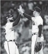  ?? THE ASSOCIATED PRESS ?? Atlanta’s Nick Markakis, left, and Freddie Freeman celebrate after the Braves defeated the Miami Marlins on Friday.