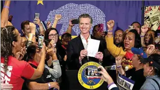  ?? ALISHA JUCEVIC / FOR CALMATTERS, FILE ?? Gov. Gavin Newsom stands with cheering fast food workers after signing legislatio­n raising their minimum wage in Los Angeles on Sept. 28, 2023.