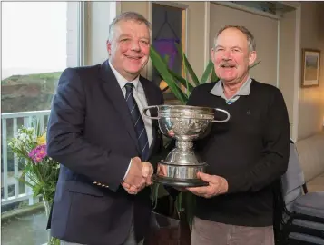  ??  ?? Blainroe Golf Club captain Peter Burgess presents Michael Kinsella with the Collins Cup trophy for 2018 at the recent AGM.