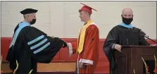  ?? BEN HASTY - MEDIANEWS GROUP ?? Colby Gromlich, 18, is presented his diploma by Hamburg Superinten­dent Richard Mextorf, left, as Damian Buggy, the Dean of Students, right, reads his name at Hamburg Area High School.