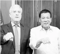  ??  ?? Duterte (right) poses with his signature fist bump with Warner who paid a courtesy call on the President at the Malacañan Palace, in Manila Philippine­s. — Reuters photo