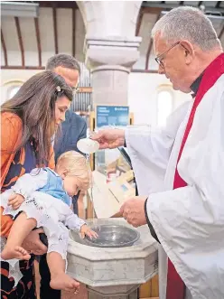  ?? Picture: PA. ?? The Rev Canon Joe Morrow carries out the first post-lockdown baptism in the Scottish Episcopal Church of 11-month-old Magnus Hutchwaite, with his parents Jeremy and Pamela Hutchwaite, at St James The Great Church in Stonehaven.