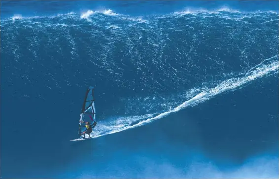  ?? ERIKAEDER.COM photo ?? Sarah Hauser drops in on her record-setting wave at Peahi on Dec. 31, 2019. Last week, Hauser was awarded the Guinness World Records title for the biggest wave ever windsurfed by a woman, a previously undocument­ed feat.