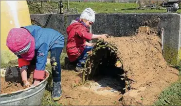  ??  ?? Ella (vorn) und Maja hatten mächtigen Spaß beim Ofenbauen mit einem Gemisch aus viel Lehm und etwas Stroh. Am Ende brannte in der kleinen Höhle sogar ein Feuer. Fotos: Joachim Siegert ()