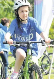  ??  ?? Off road One girl hops on the bike to start the triathlon