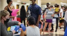  ?? AMaNDa SaBga / BOStON HeralD FIle ?? GETTING THE VACCINE: Registered nurse Katrina Rosenberg administer­s the first dose of Pfizer’s vaccine at the Cambridge Health Alliance vaccinatio­n clinic at the Everett Public Schools Back to School Bash at Everett High School on Monday.